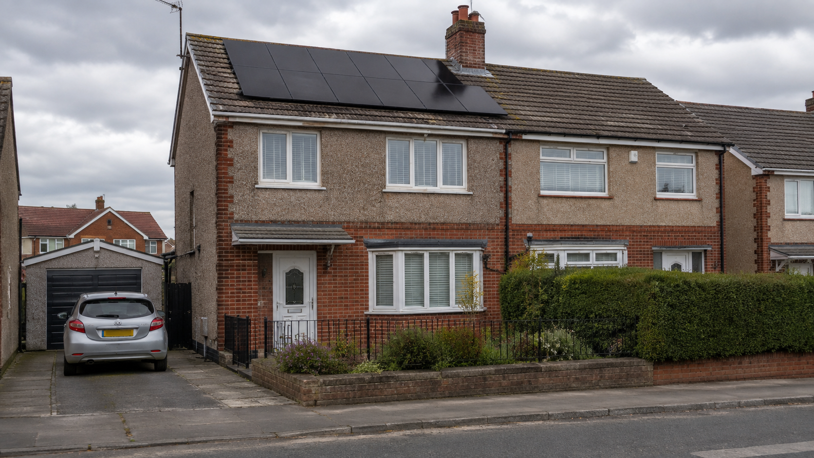 UK semi-detached house with black solar panels on the roof, silver hatchback on the driveway, pebbledash and brick front